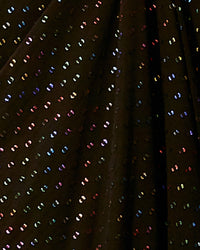 A close-up of a multicolored sequined black fabric.