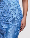 A close-up of a blue evening dress featuring an embroidered guipure bodice.