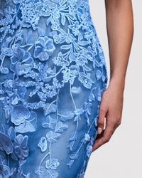 A close-up of a blue evening dress featuring an embroidered guipure bodice.