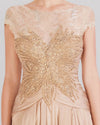 A close-up of a beige evening dress featuring a beaded lace bodice, short sleeves, and a gathered skirt.