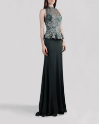 An evening wear set featuring a lace halter top in shades of green with a ruffled waist paired with a long flowy green skirt.