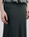 A close-up of a long flowy green skirt.