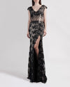 A long black lace evening dress with small sleeves and a zigzag see-through waist detailing.