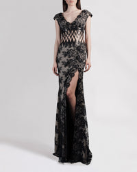 A long black lace evening dress with small sleeves and a zigzag see-through waist detailing.