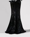 The back of a long black mermaid cut skirt in a shimmery mesh fabric.