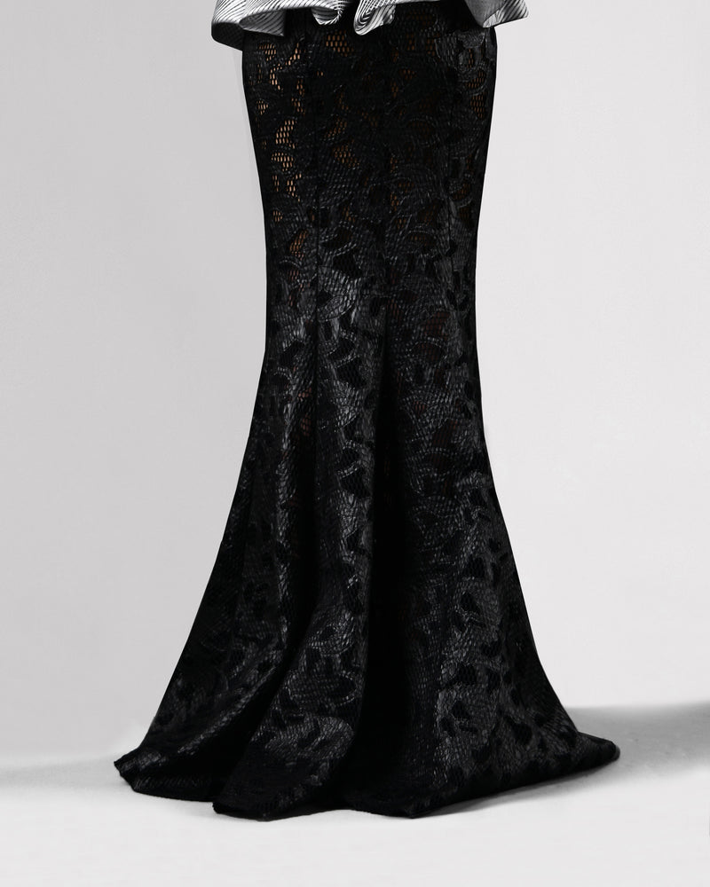 The back of a long black mermaid cut skirt in a shimmery mesh fabric.
