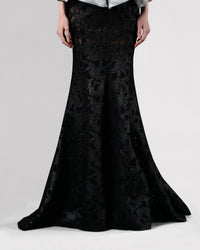 A long black mermaid cut skirt in a shimmery mesh fabric.