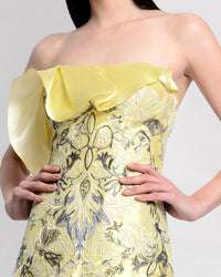 A close-up of a strapless yellow evening dress featuring a ruffled neckline and a lace bodice.