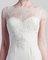 A close-up of an ivory dress featuring a beaded lace bodice with short-sleeves.