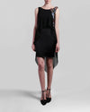 A short black evening dress with an asymmetrical chiffon overlay, featuring beading detail on one shoulder.