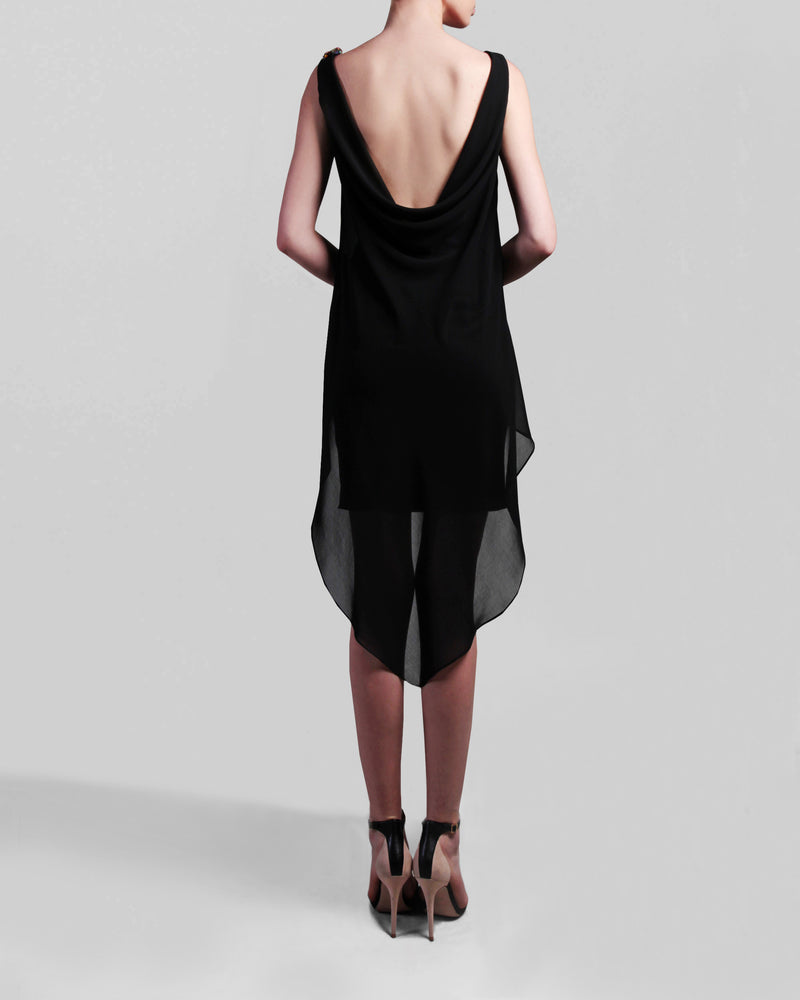 The back of a short black evening dress with an asymmetrical chiffon overlay, featuring an open back.